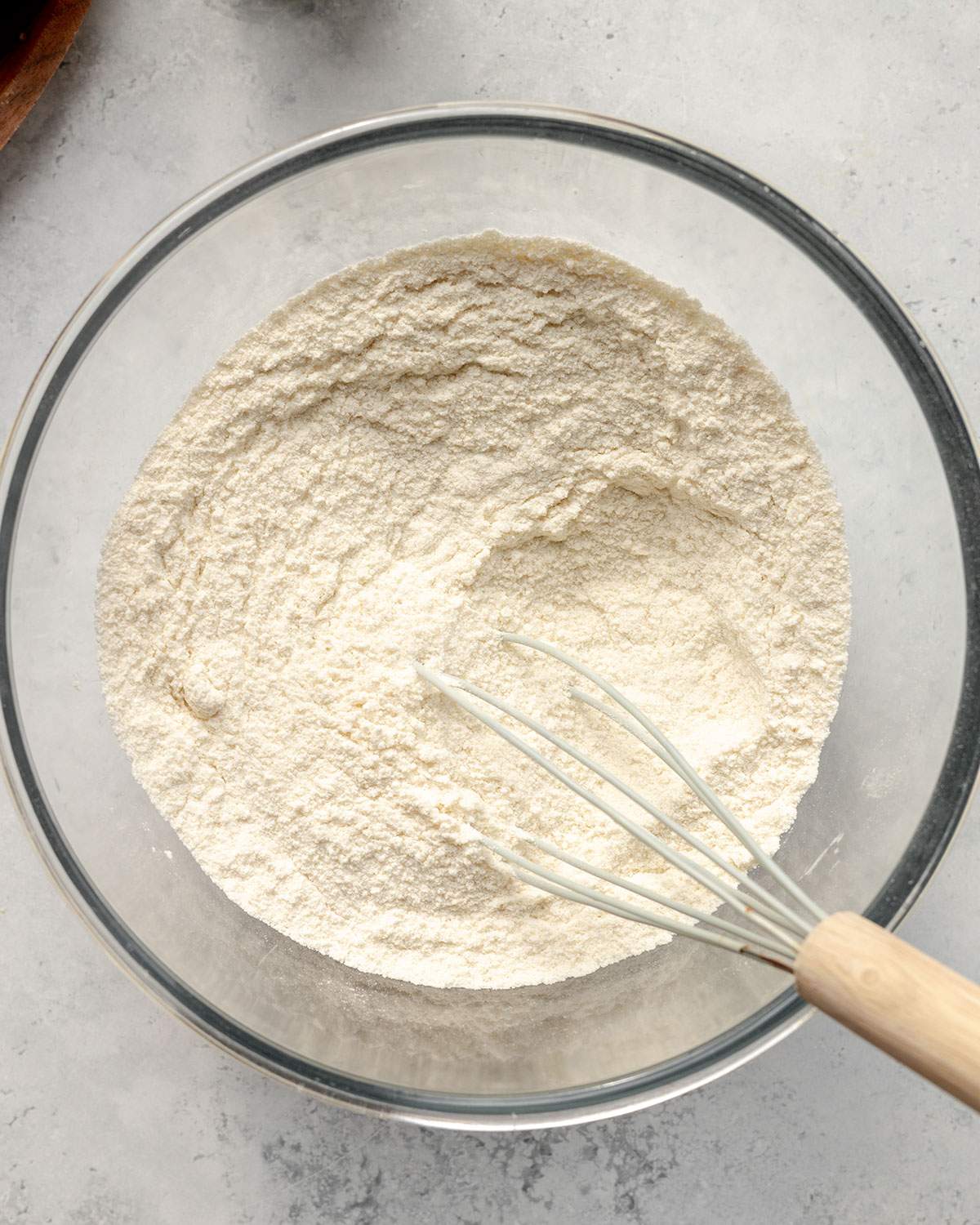 Vegan apple cake dry ingredients whisked together in a glass mixing bowl.