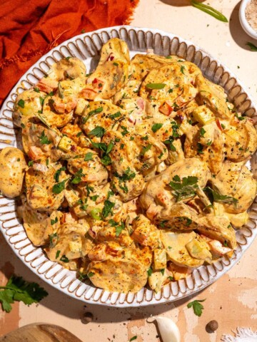 Cajun potato salad recipe with roasted potatoes, creamy dressing and fresh herbs.