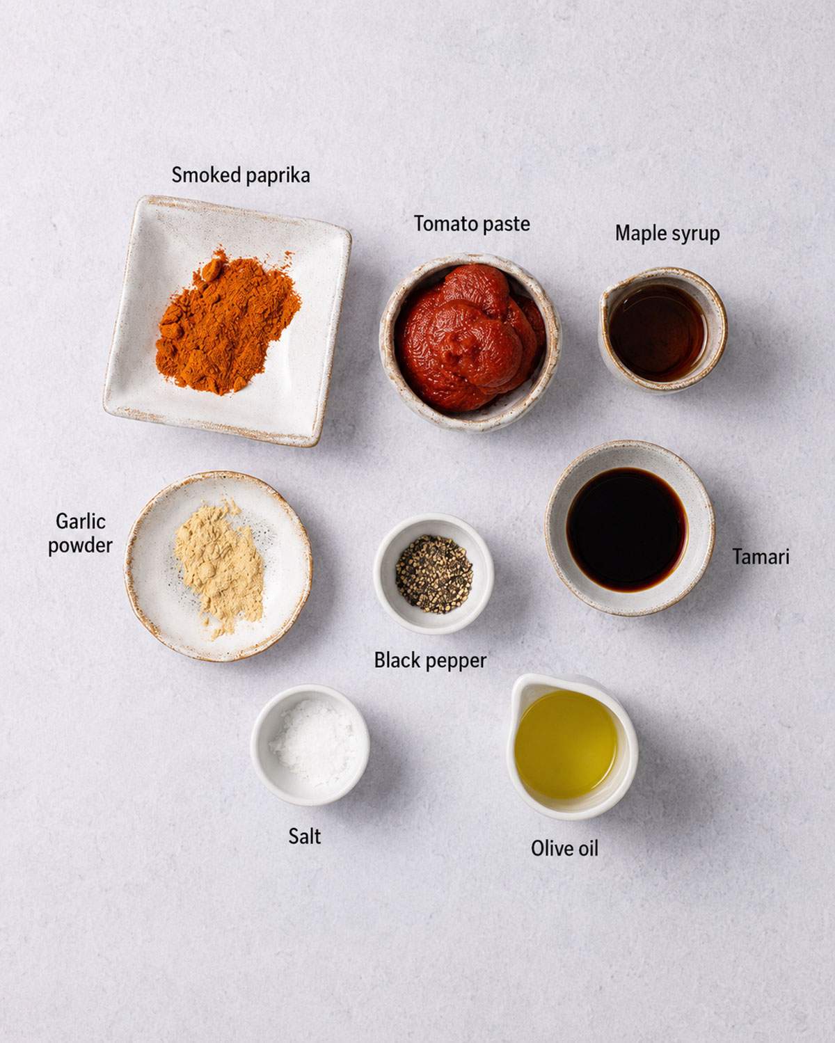 Ingredients for vegan grilled chicken, including smoked paprika, garlic powder, tomato paste, tamari, maple syrup, olive oil, salt, and black pepper.