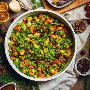 Caramelized brussels sprouts in a skillet on the dinner table with fresh herbs on top.